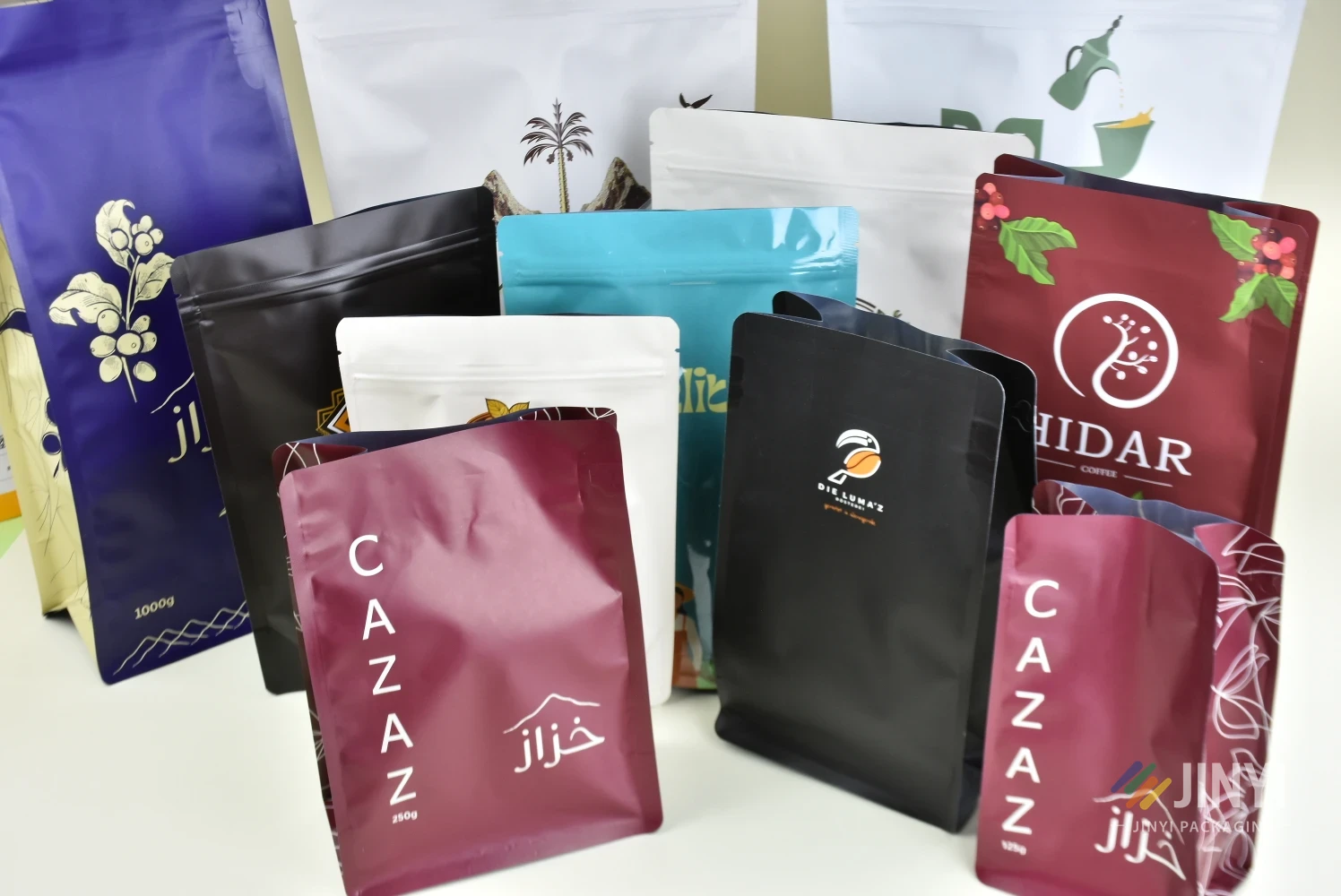 JINYI custom coffee bag production cases — multiple formats, finishes, and brand designs produced factory-direct for coffee brands worldwide