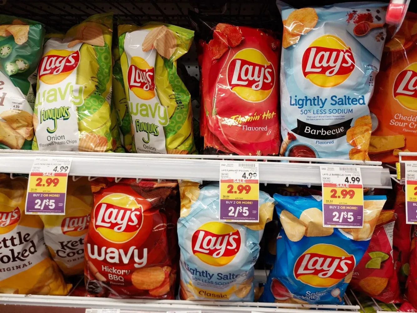 Row of Lay's potato chip bags displayed on a supermarket shelf
