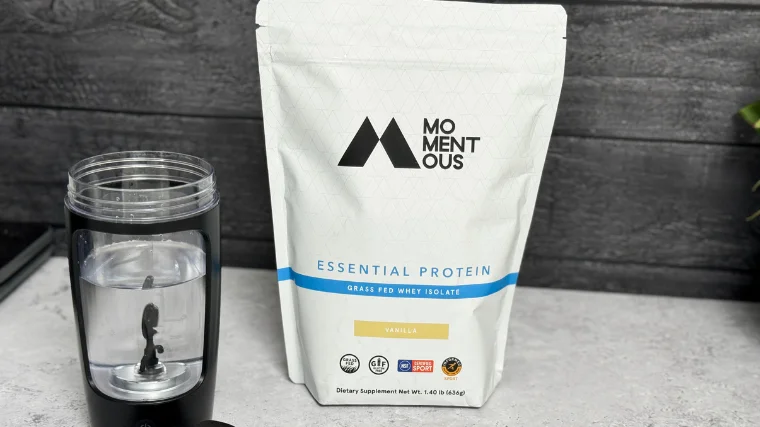 Momentous Essential Protein whey isolate stand-up pouch with glass — minimal white packaging in daily supplement routine