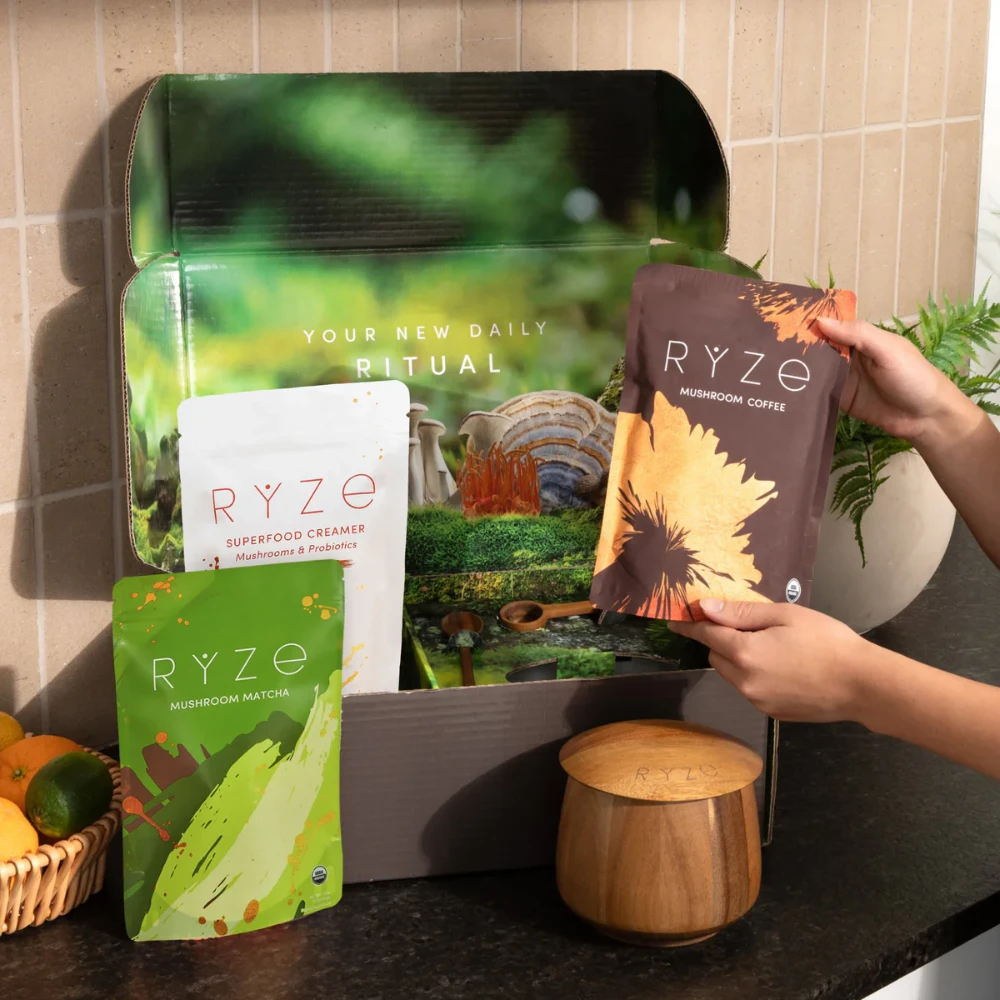 RYZE Mushroom Coffee unboxing scene showing full product range — mushroom coffee matcha and superfood creamer stand-up pouches in your new daily ritual DTC packaging presentation