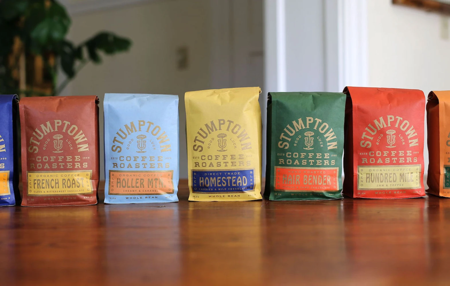 Stumptown Coffee color-coded bag range in grocery lineup — blend and single origin bags showing full color system
