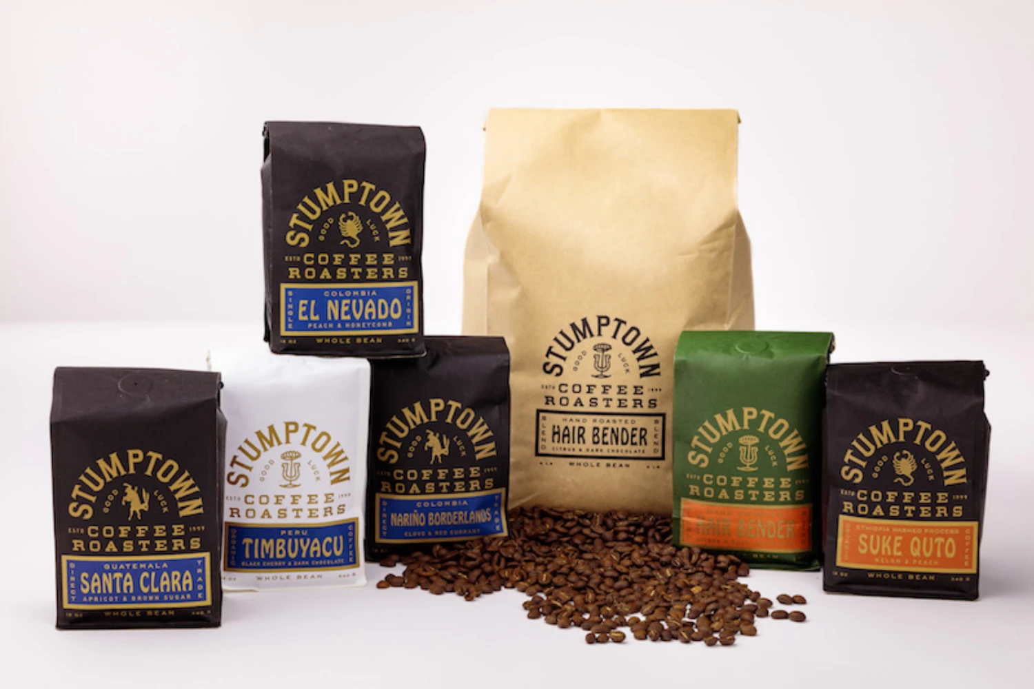 Stumptown Coffee full packaging range — single origin black bags and colorful blend bags with coffee beans display