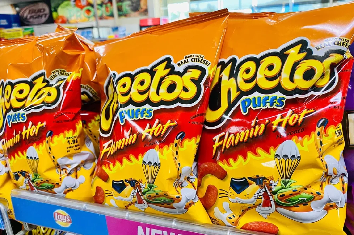 Cheetos Flamin Hot and Puffs bags displayed on a retail store shelf
