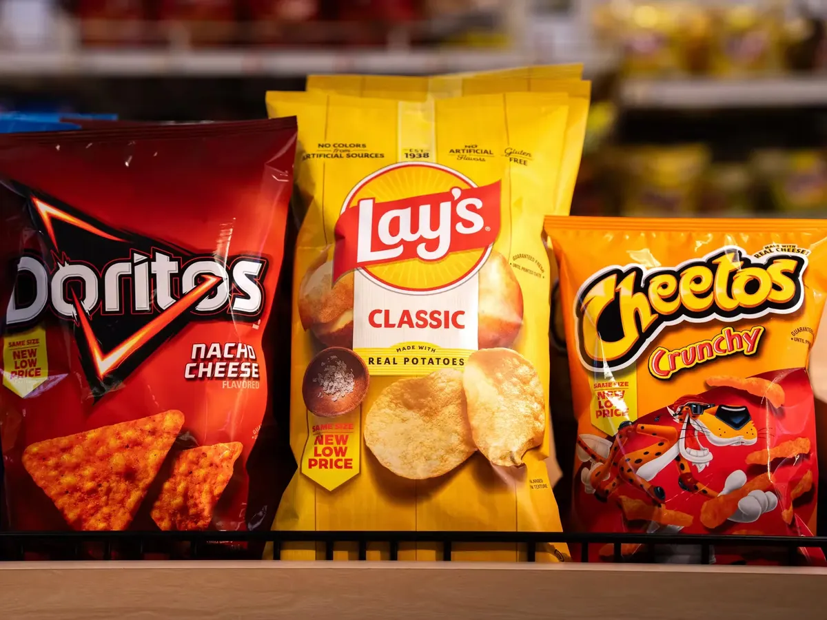 Doritos, Lay's and Cheetos snack bags displayed together on a retail store shelf
