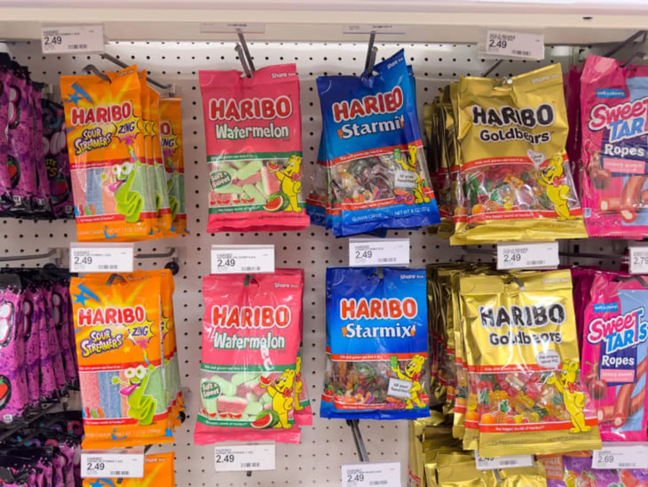 Multiple Haribo gummy candy bag varieties displayed together on a retail store shelf