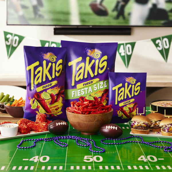Two Takis Fiesta Size bags displayed on a football field themed party table