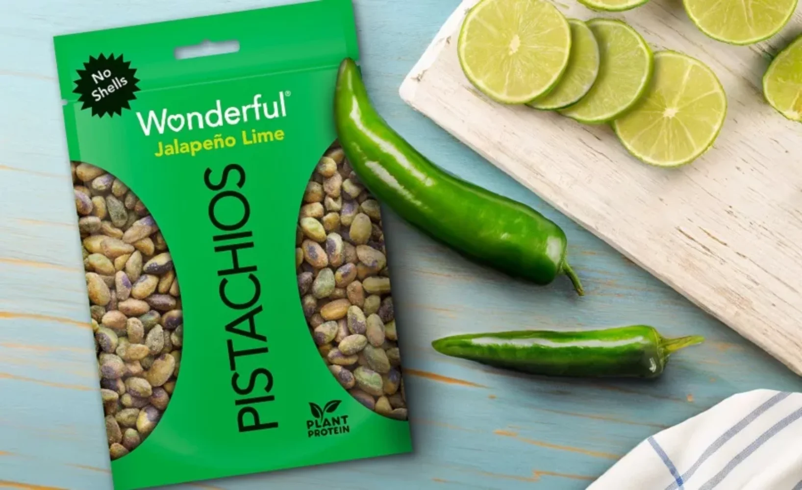 Wonderful Pistachios Jalapeño Lime flavored bag displayed with fresh jalapeños and lime
