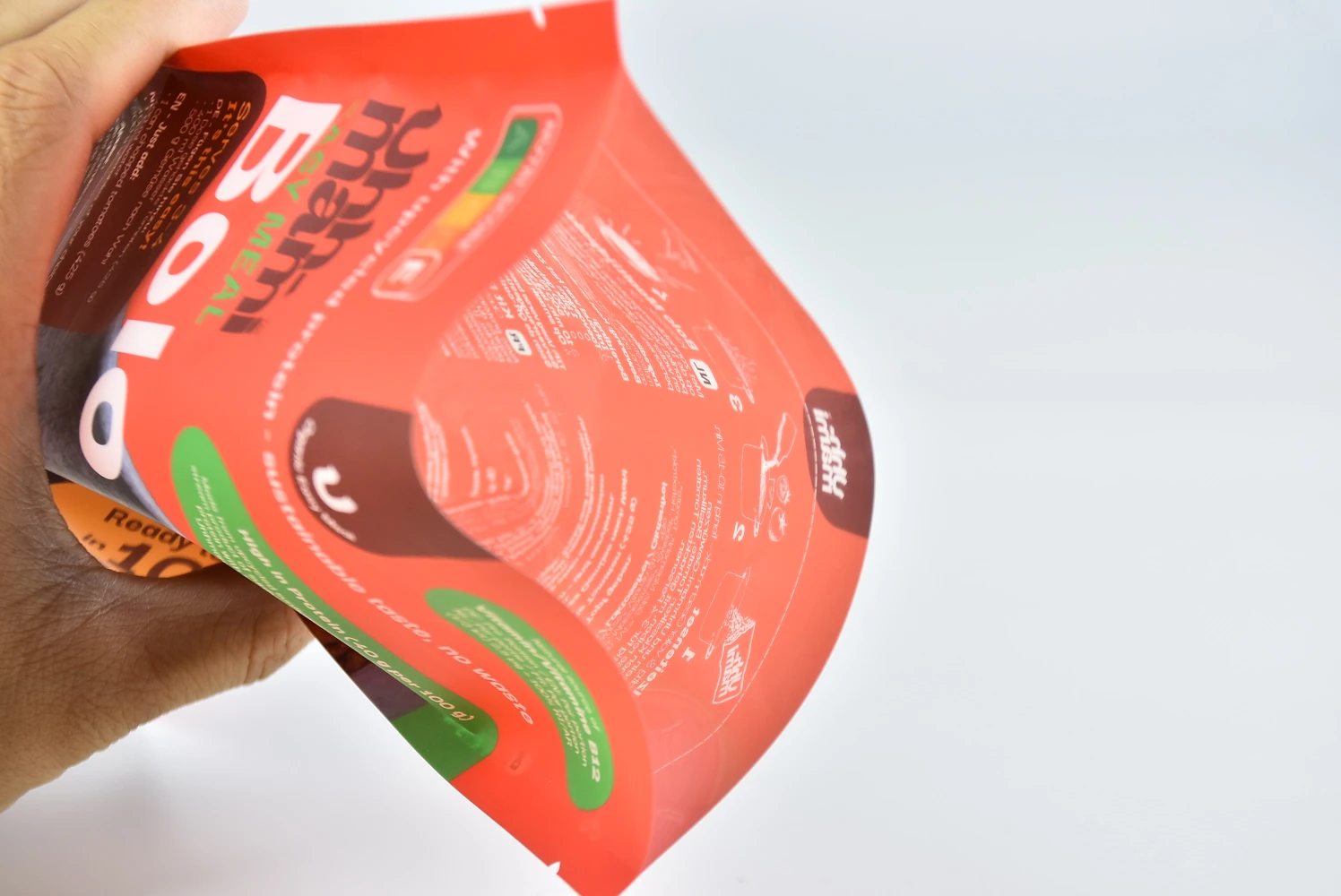 Hand bending a soft recyclable PE stand-up pouch to show its flexible material structure